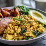 Savory Tofu Scramble Vegan Breakfast Bowl with sautéed spinach, fluffy quinoa, and golden roasted sweet potatoes.