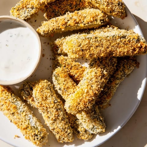 Golden-brown fried pickles with a satisfying crunch, ready to dip in creamy, cool ranch dressing.