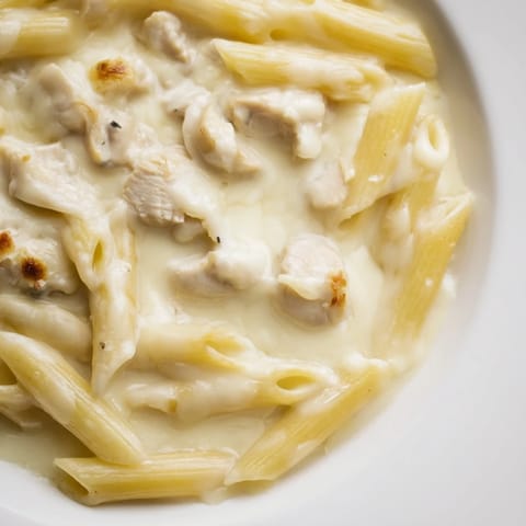 Hearty serving of Chicken Alfredo Casserole with tender chicken pieces and fresh parsley garnish, ideal for a comforting family dinner.  