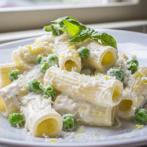 Spring-inspired pea and lemon ricotta pasta tossed with sweet green peas and vibrant lemon zest.