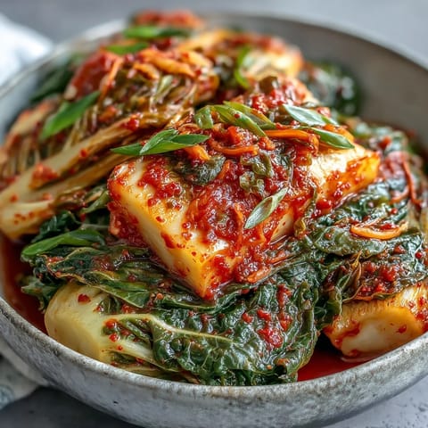 Fermenting kimchi with fresh ginger, garlic, and gochugaru in a stoneware crock, ready for days of tangy development.  