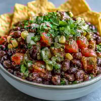 Vibrant 3-ingredient cowboy caviar dip with black beans, corn, and pico de gallo in a white bowl.